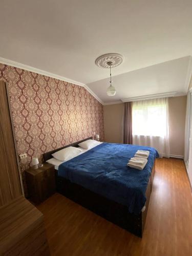 a bedroom with a blue bed with a blue blanket at Mestia Residence in Mestia