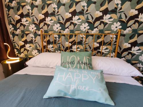 a bed with a pillow that says happy place at OSTIA HOME in Lido di Ostia