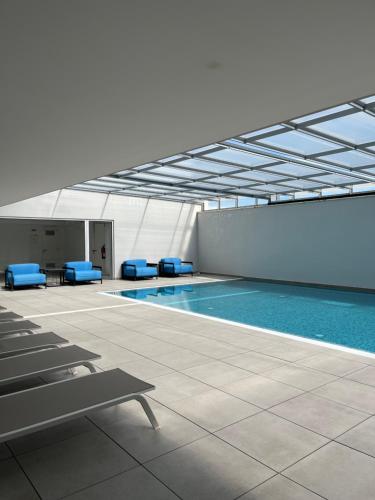 a swimming pool with blue chairs in a building at Sesimbra Blue Paradise in Sesimbra