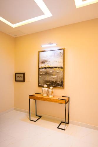 a table in a room with a painting on the wall at Pavilion Suites - Premium ApartHotel in Bahria Town in Rawalpindi