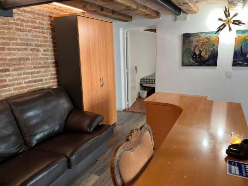 uma sala de estar com um sofá de couro e uma mesa em Cataluña Room em Barcelona