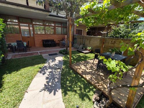 a backyard with a table and chairs and a tree at OSTIA HOME in Lido di Ostia