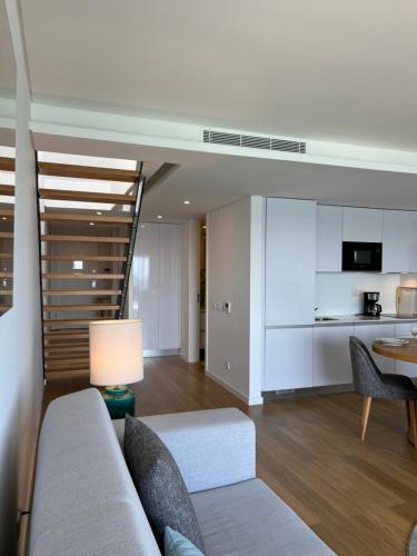 a living room with a couch and a kitchen at Sesimbra Blue Paradise in Sesimbra
