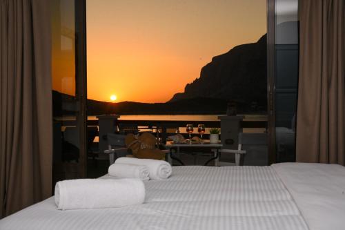 a bedroom with a bed with a view of the sunset at Australia Apartments in Kalymnos