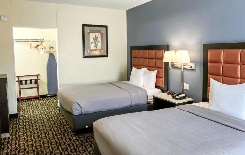 A bed or beds in a room at Quality Inn Airport - Cruise Port