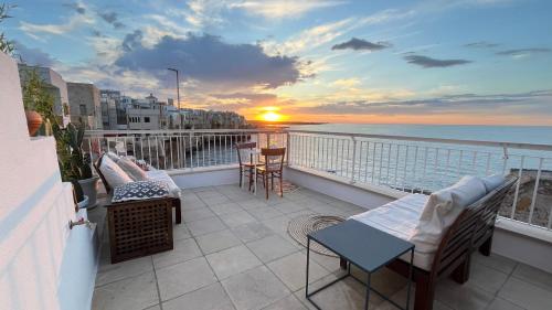 a balcony with a view of the ocean at sunset at Bella Vista Grotta Ardito in Polignano a Mare