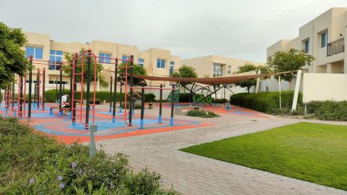 um parque infantil em frente a um edifício em Damac Hills 2 Retreat- Tranquil Luxe, Beyond City with waterpark no Dubai