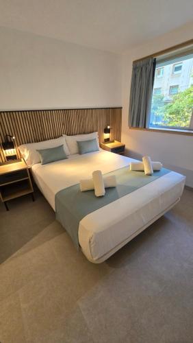 un grand lit dans une chambre avec une grande fenêtre dans l'établissement Hostal Rambla 24 by Holihome, à Alicante