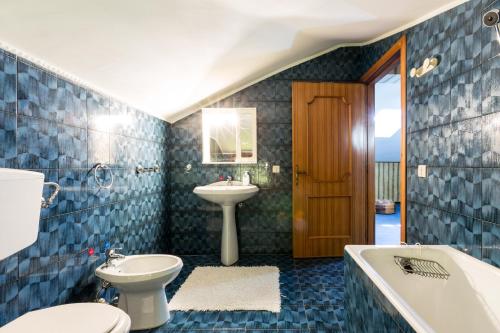a bathroom with a toilet and a sink and a tub at Villa Bea by BarbarHouse in Taranto