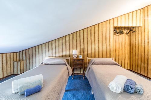 two beds in a room with wooden walls at Villa Bea by BarbarHouse in Taranto