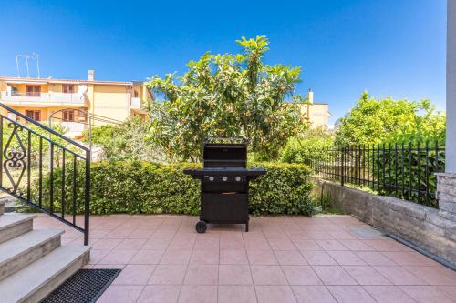 a black table sitting on a sidewalk next to a fence at Villa Bea by BarbarHouse in Taranto