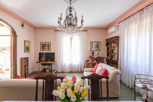 a living room with a chandelier and a couch at Villa Bea by BarbarHouse in Taranto