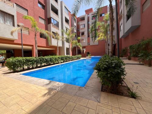 ein Schwimmbad in der Mitte eines Gebäudes in der Unterkunft ASAMA appartement avec piscine in Marrakesch