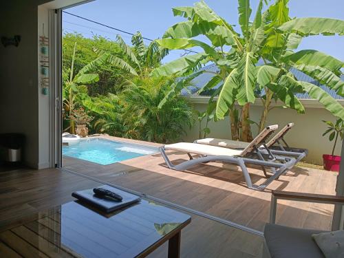 a patio with a chair and a swimming pool at Soley Bungalows Carambole 2 pers Adult only in Sainte-Anne