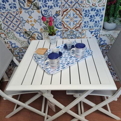a white table with cups and saucers on it at Gemma del mare in Crotone