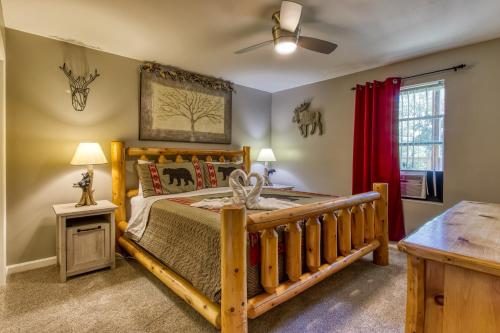 a bedroom with a wooden bed and a table at Fun & Games by HoneyBearCabins 2BR/1BA Sleeps 7 in Sevierville