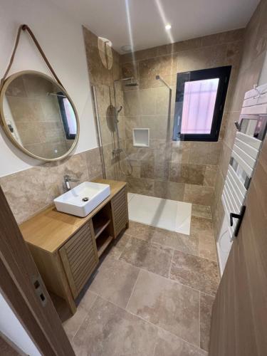 une salle de bain avec un lavabo et une douche avec un miroir dans l'établissement Villa roche blanche 1, à La Verdière