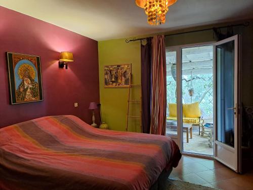 une chambre avec un lit et une porte coulissante en verre dans l'établissement villa, à Arles