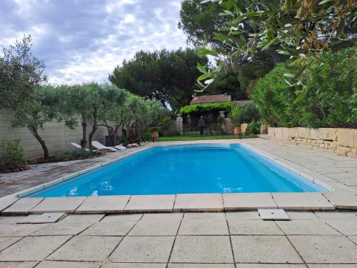une grande piscine bleue dans une cour dans l'établissement villa, à Arles