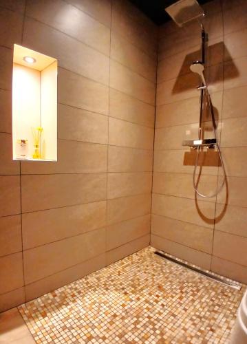 La salle de bains est pourvue d'une douche avec un miroir et de carrelage. dans l'établissement La Passionnante Gîte avec Spa privatif, à Saint-Philbert-de-Bouaine