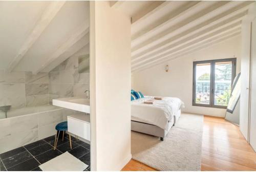 - une chambre blanche avec un lit et une salle de bains dans l'établissement La belle de Bouliac, à Bouliac