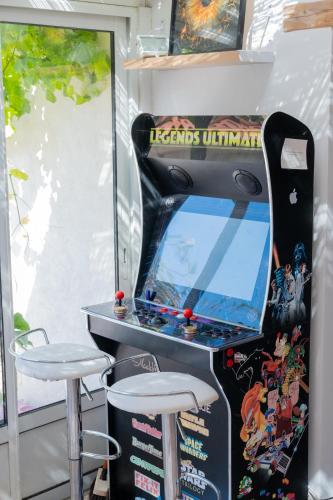 a video game arcade with two stools in front of it at CASA MONICA CARGESE - Roseroom - Chambre d hote in Cargèse