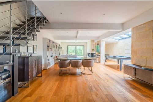 - une grande cuisine avec une table et des tabourets dans l'établissement La belle de Bouliac, à Bouliac