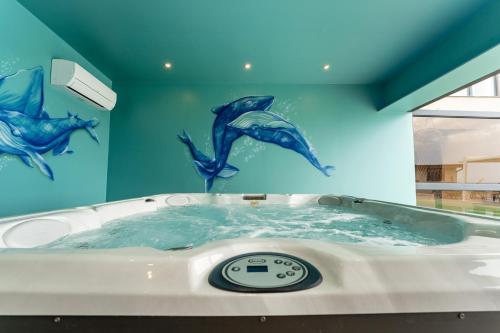 a bath tub with dolphins painted on the wall at Giovannino House in Catania