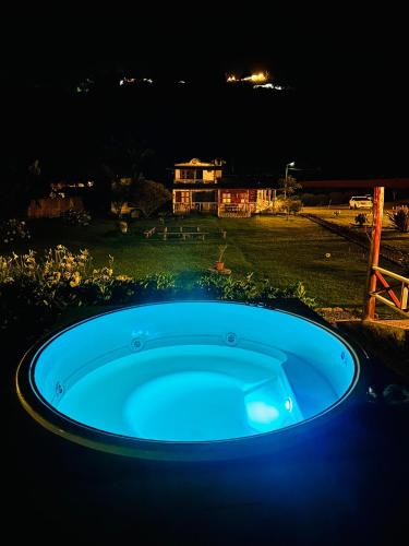 a blue hot tub in a yard at night at Riverside La Masía Ecohotel in Quindío