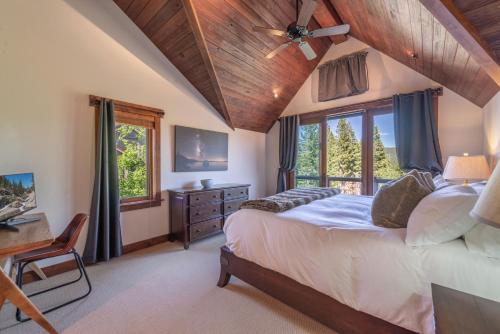a bedroom with a bed and a desk and windows at Luxury Northstar Home Walk to Lifts Private Hot-Tub Fenced-In Yard Book on Mobile for Promo Price in Truckee