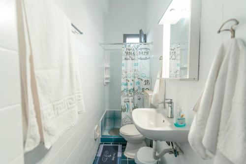 un bagno bianco con lavandino e WC di Kuburno House - Spacious - close to the beach apartment a Città di Kos