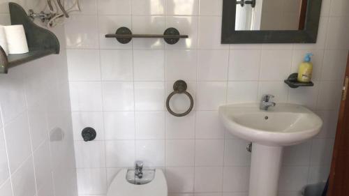Un baño blanco con lavabo e inodoro. en Casas Navarredonda, en Navarredonda
