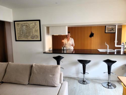 a woman standing behind a counter in a living room at Apartamento familiar no centro histórico - Afonso Henriques in Braga