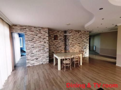 a dining room with a table and a brick wall at 216м апартаменты на пляже Уреки для отдыха большой семьи или компании in Ureki