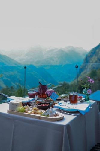 a table with food on it with mountains in the background at Hotel Thethi in Theth