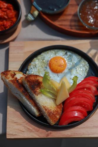 a plate of breakfast food with eggs and peppers and toast at Hotel Thethi in Theth