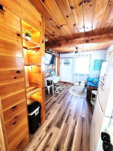 a room with wooden walls and a kitchen with a refrigerator at Sea & Sun Cottage #1 in Hampton