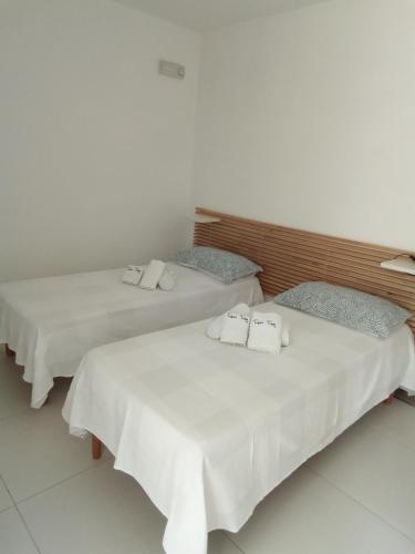 two beds with white sheets and towels on them at Rescio's Rooms in Cavallino di Lecce