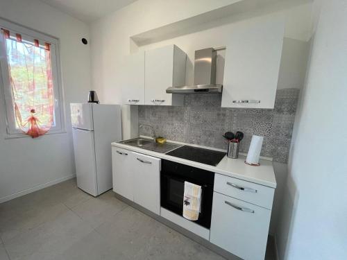 a kitchen with white cabinets and a white refrigerator at Relax a pochi passi dal Mare in Arcola