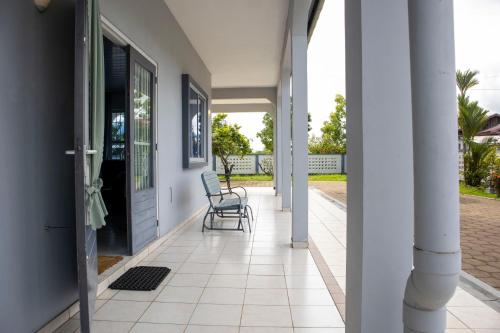 a porch with a chair on a house at Sabajo appartement verhuur in Paramaribo
