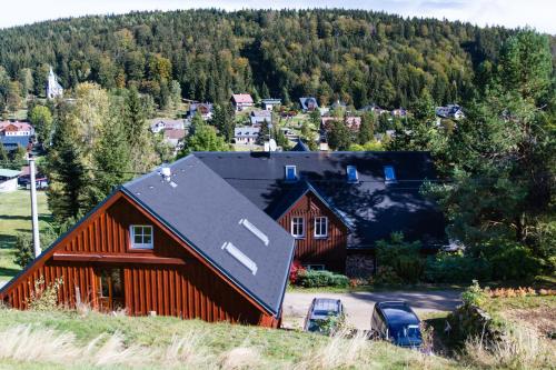 an orange barn with a black roof on a mountain at Bedřichovská Devítka in Bedřichov