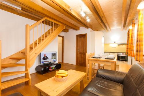 a living room with a spiral staircase and a kitchen at Bedřichovská Devítka in Bedřichov