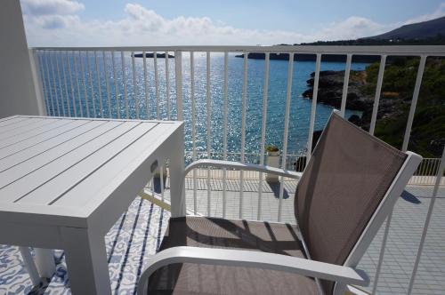 a table and chair on a balcony with a view of the water at Casa del Mare Rooms & Apartments in Marina di Camerota