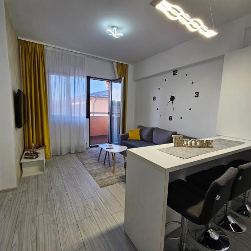 a kitchen and living room with a large clock on the wall at Apartament Dem Rădulescu langa strand in Râmnicu Vâlcea