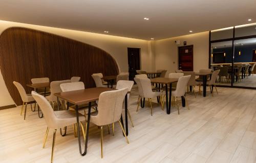 a restaurant with tables and chairs in a room at PEROLA HOTEl in Maputo