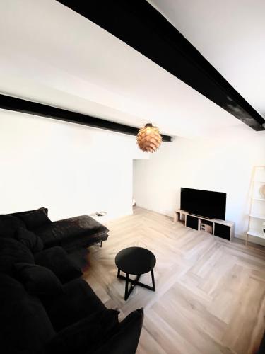 un salon avec un canapé noir et une table dans l'établissement La pinéa, à Port-la-Nouvelle