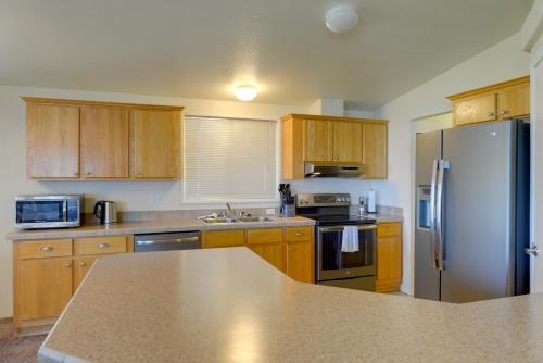 a kitchen with wooden cabinets and a stainless steel refrigerator at Smith River Home with Boat Launch and Ocean Views in Smith River