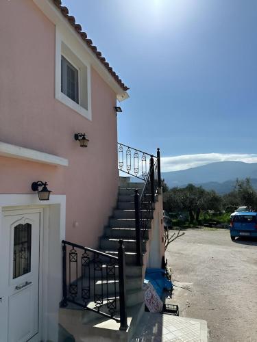 a set of stairs next to a pink building at Eva's Apartments in Karlovasi