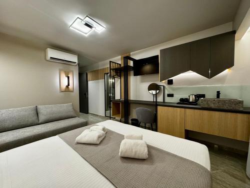 a room with a bed and a couch and a kitchen at Costa De Luxe Suites in Leptokaria