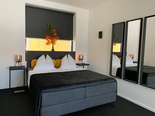 um quarto com uma cama grande e 2 espelhos em Wellness Dome Penthouse em Kerkrade